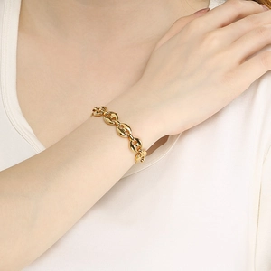 Detail of 13mm gold stainless steel pig nose link bracelet worn on a female wrist