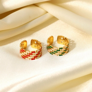 Detail of 18K gold plated woven rings with red, green and white enamel grid patterns