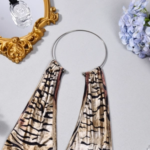 Detailed view of silver metal ring and tiger print velvet fabric for backless bodysuit