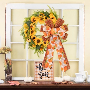 Detail of fall harvest wreath featuring sunflowers, pumpkins and large orange plaid bow