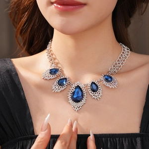 Detail of necklace with blue teardrop crystal and shimmering diamonds on elegant silver chain
