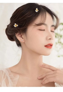 Close-up of s925 silver branch stud earrings with zircon and daisy hair clips on model