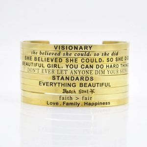 Stack of 4mm gold stainless steel open bangles with inspirational engraved quotes