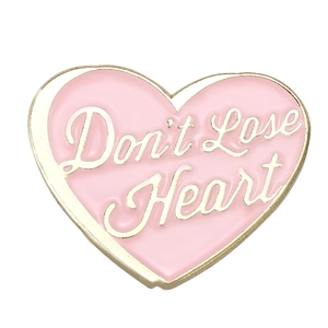 Pink heart enamel pin with gold Don't Lose Heart lettering on a white background