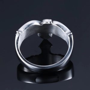 Detailed top view of a Claddagh ring with heart and crown motif on black mirror surface