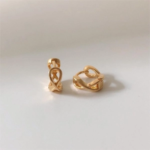 Macro shot of gold infinity knot huggie earrings with a polished finish and elegant design