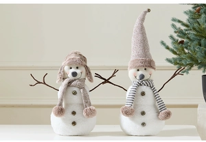 Detail of plush snowman Christmas gnomes with knit hats and faux wood branches decoration