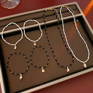 Bohemian shell necklace and bracelet set with black and white beads and gold charms
