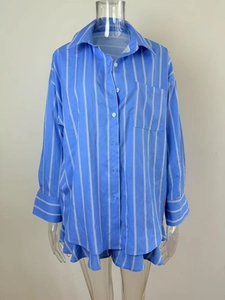 Detail of blue and white striped long sleeve shirt with front pocket and button cuffs