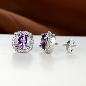 Close-up of square purple zircon stud earrings with micro-pave white halo on silver metal