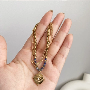 Double-layer gold titanium steel bracelet with blue beads and evil eye charm
