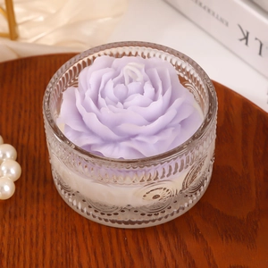 Romantic purple rose scented candle in embossed glass jar on vintage wooden table
