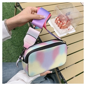 Detailed macro view of colorful gradient crossbody bag with wide strap and silver metal hardware