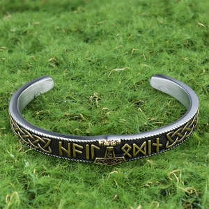 Detail view of Viking rune hammer cuff with antique silver finish on green grass background