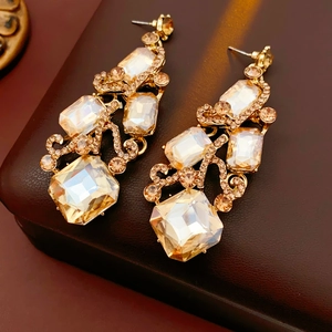 Detail view of vintage gold chandelier earrings with champagne faceted crystals