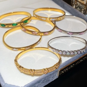 Macro detail of luxury bangle collection with marquise zircons and pavé heart in a jewelry box