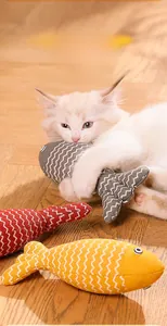 Nahaufnahme eines Kätzchens, das mit einem fischförmigen Katzenminze-Spielzeug spielt