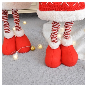 Detail of knitted striped legs and red plush boots on a Christmas standing doll
