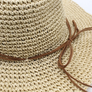 Beige woven straw sun hat with wide brim and brown faux-suede ribbon bow detail