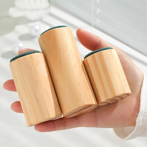 Three-piece solid wood ring display set with green velvet top held by a hand