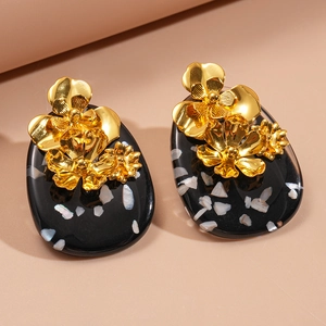 Vintage oval resin earrings with gold metallic flowers and shell inlay on beige background