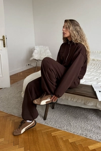 Detail of chocolate brown loungewear set featuring a half-zip sweatshirt and joggers