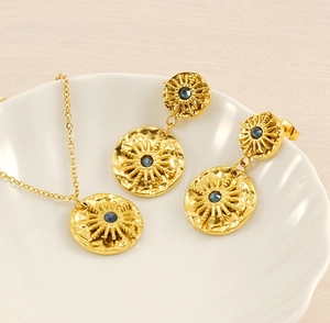 Détail de l'ensemble collier et boucles d'oreilles étoile dorée et gemmes bleues