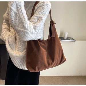 Brown suede tote bag shown on a model in a cozy white knit sweater for a vintage style