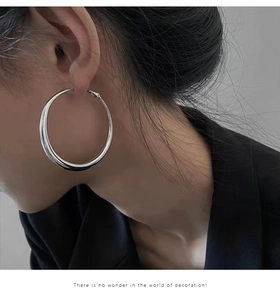 Silver large hoop earrings for women with minimalist design shown on a female model profile