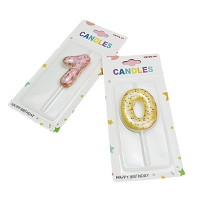 Creative donut-style number 7 and 0 birthday candles with colorful sprinkles on white