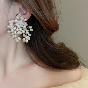 Detail view of woven pearl cluster flower earrings in French vintage style on model