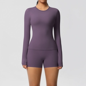 Close-up of deep purple high-waisted fitness shorts and long-sleeved athletic top