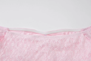 Close-up of pink lace neckline with elastic band and premium stitching on evening dress