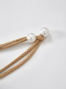 Close-up of beige jute rope with white pearl accent showing natural fiber texture