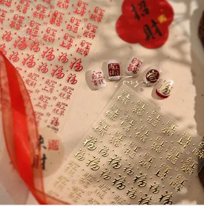 Detail of red and gold Chinese calligraphy nail stickers with festive lucky symbols