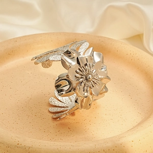 Macro detail of silver blooming flower petal and textured leaf on this statement arm cuff