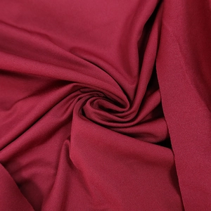 Detailed macro view of burgundy knit fabric texture and soft drape of the dress