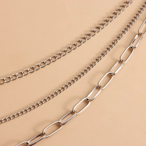 Detailed view of triple-layered silver metal waist chains with varied link styles