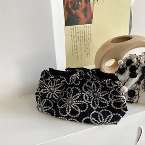Exquisite black clutch bag featuring white daisy embroidery and a white pearl zipper pull