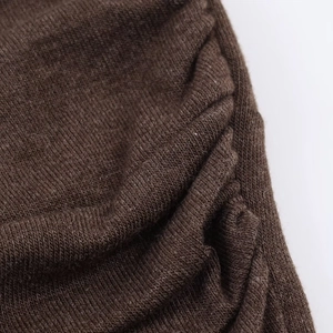 Macro detail of brown knitted fabric texture featuring pleated design craftsmanship