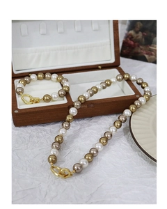 Elegant multi-color pearl necklace and bracelet set displayed on a wooden jewelry box