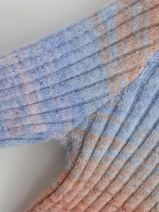 Close-up of blue and orange gradient knit sweater showing rib knit texture and fuzzy mohair fiber