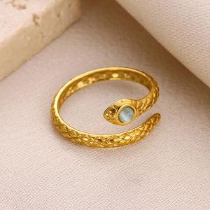 Detail of snake ring featuring golden scales and a green cat-eye gemstone setting