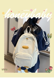 Detail view of cute cream corduroy duck backpack with 3D yellow beak and webbed feet