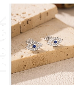 Detailed close-up of S925 sterling silver evil eye stud earrings with blue crystals