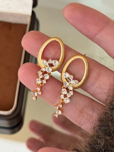 Détail de boucles d'oreilles ovales dorées avec des pampilles en cristal vintage