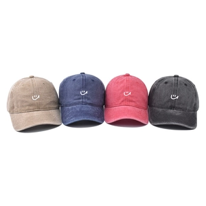 Washed cotton baseball caps in four colors featuring a minimalist white embroidered smile