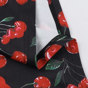 Detailed close-up of cherry pattern print on premium black knit dress with neat stitching