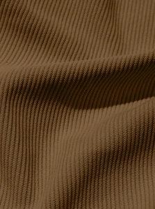 Close-up of the thick corduroy fabric texture and soft brown material on the shirt