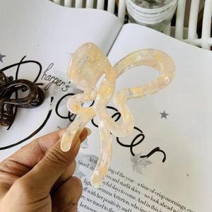 Detail of cream acetate butterfly hair claw with marble texture and elegant finish